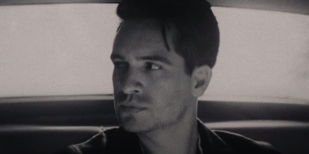 Black and white portrait of Brendon Urie inside a car